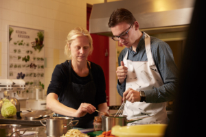 cursist en kok samen achter fornuis